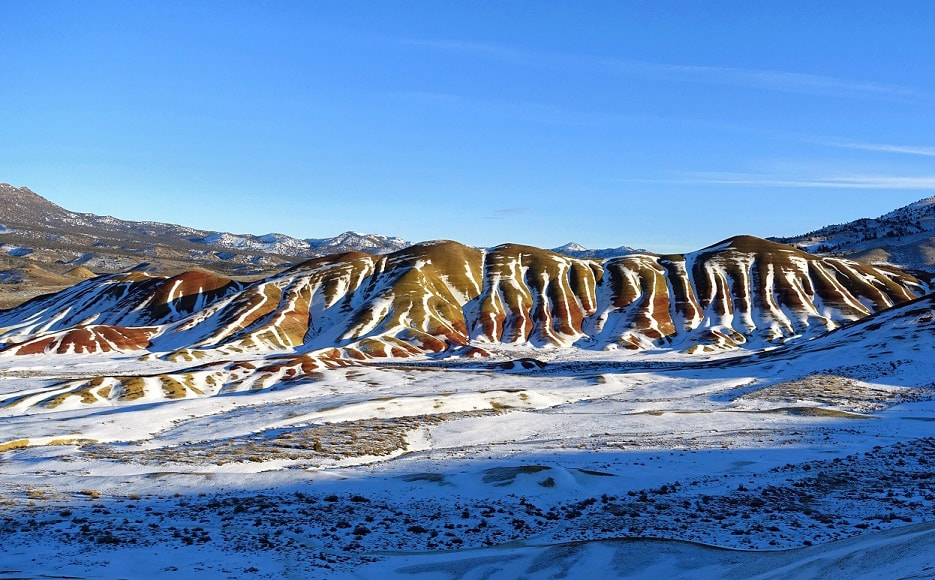 Bright colors showing through the snow at the Painted Hills of Oregon